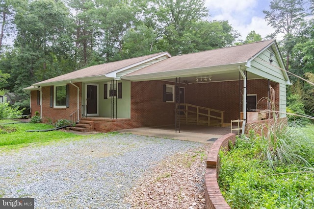 8305 Old Plank Rd, Fredericksburg, VA 22407 - single story home featuring a carport, gravel driveway, brick siding, and roof with shingles