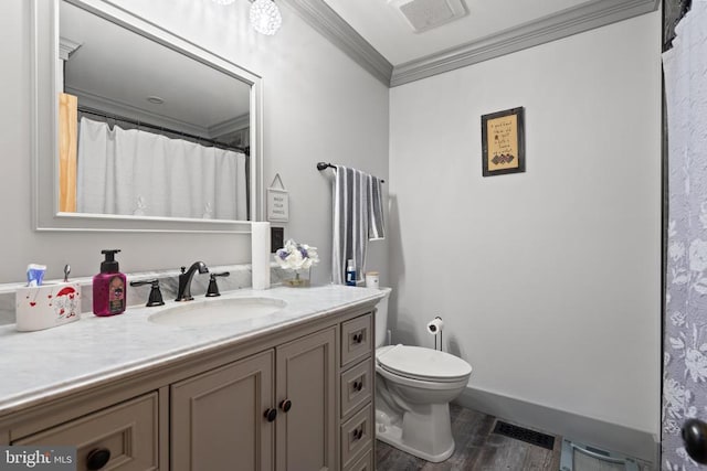 bathroom with crown molding, wood finished floors, toilet, vanity, and baseboards