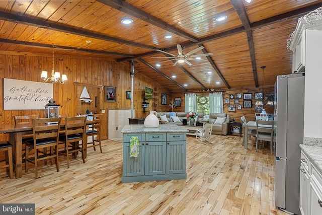 kitchen featuring green cabinetry, freestanding refrigerator, wooden walls, light wood finished floors, and wood ceiling