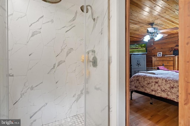 bathroom featuring a marble finish shower, wooden ceiling, wood walls, wood finished floors, and a ceiling fan