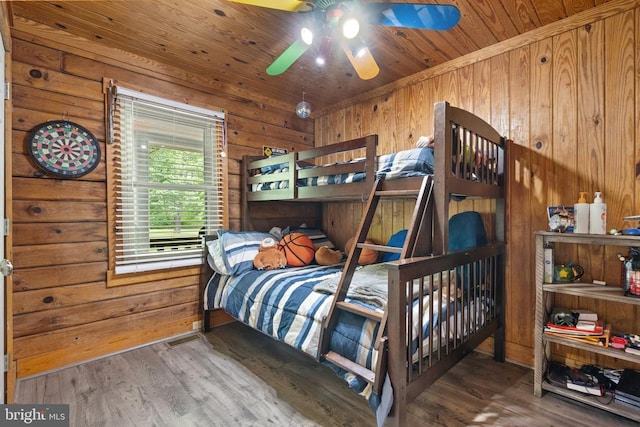 bedroom with wood walls, wood finished floors, and wooden ceiling