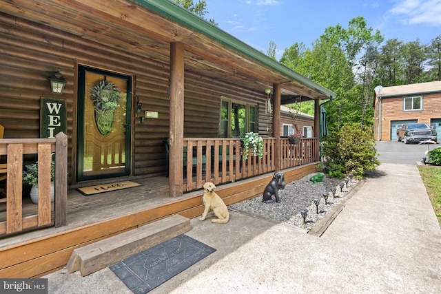 view of exterior entry featuring covered porch