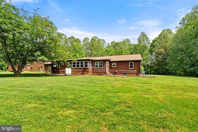 rear view of property featuring a yard