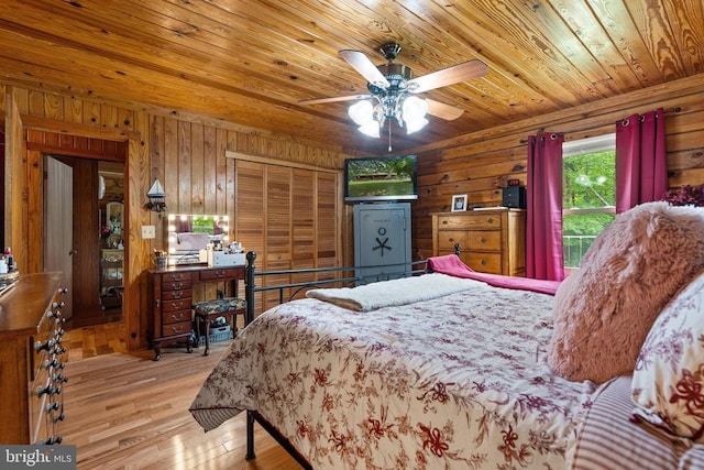 bedroom with wood ceiling, wooden walls, wood finished floors, a closet, and a ceiling fan