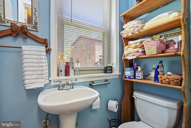 half bathroom featuring toilet and a sink