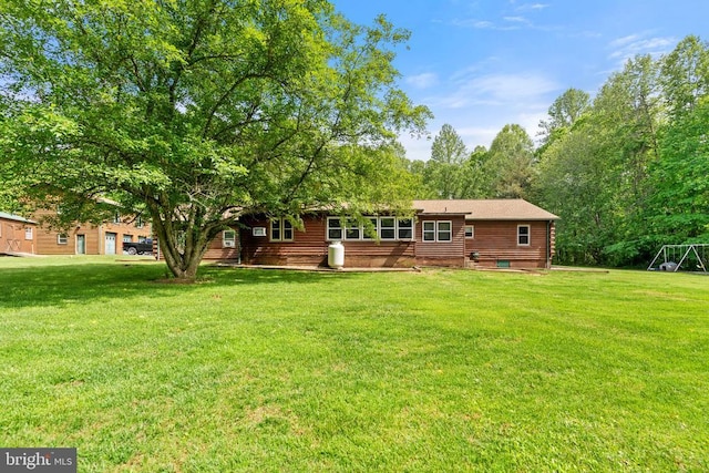 rear view of house featuring a yard