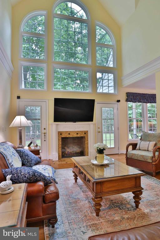 13608 General Slocum Ct S, Fredericksburg, VA 22407 - living room with a high ceiling, a glass covered fireplace, and wood finished floors