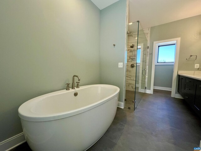 full bath with a stall shower, vanity, baseboards, and a freestanding bath