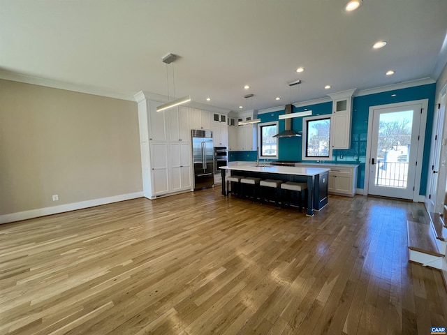 kitchen with white cabinetry, crown molding, built in refrigerator, hardwood / wood-style floors, and light countertops