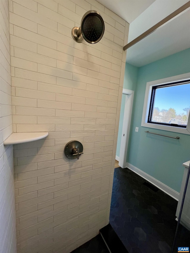 full bathroom with baseboards and tiled shower