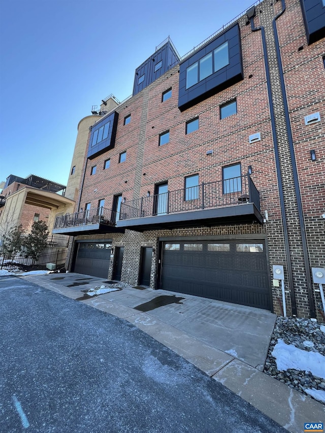 view of property featuring concrete driveway and an attached garage