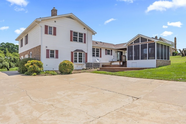 336 Hollingsworth Rd, Woodstock, VA 22664 - rear view of property with a chimney, a sunroom, brick siding, and a yard