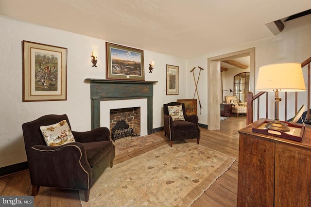 living area featuring wood finished floors, a fireplace, and baseboards