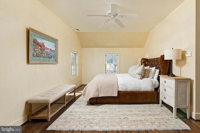 bedroom with lofted ceiling, visible vents, dark wood-style flooring, a ceiling fan, and baseboards