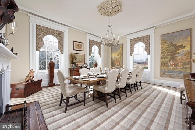 dining room with a notable chandelier, crown molding, and plenty of natural light