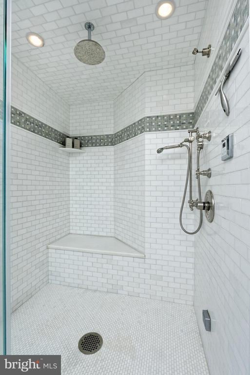 full bathroom with tile patterned floors and a tile shower