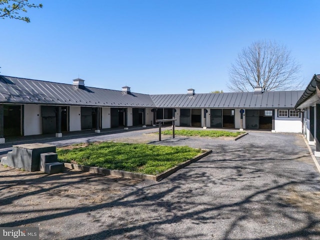 ranch-style home with metal roof and a chimney