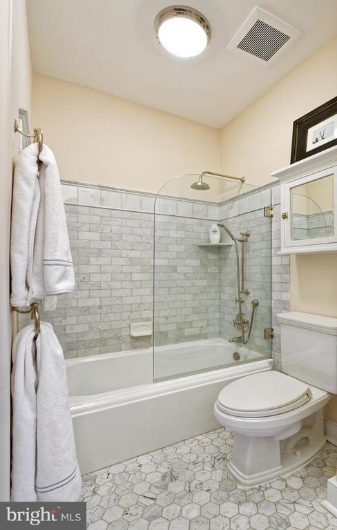 bathroom featuring toilet, shower / bath combination, tile patterned flooring, and visible vents