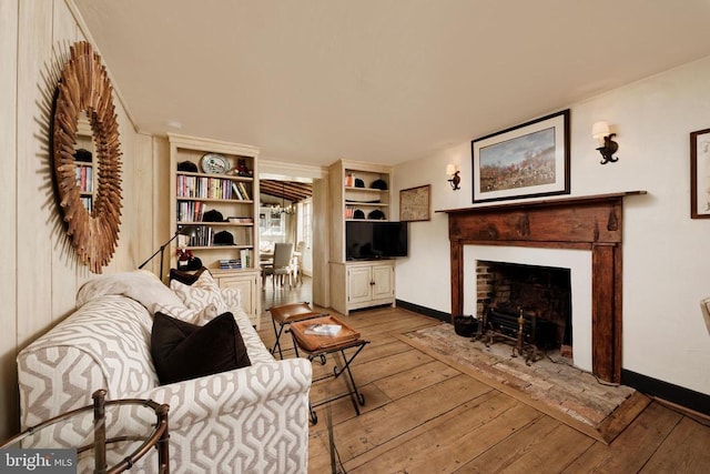 living room with a fireplace with flush hearth, baseboards, and hardwood / wood-style floors