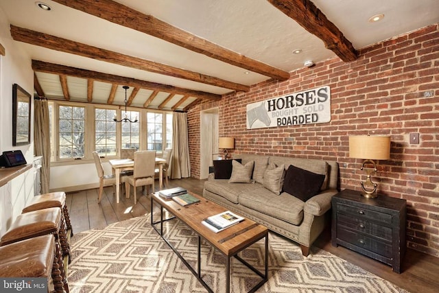 living room with brick wall, hardwood / wood-style flooring, and vaulted ceiling with beams