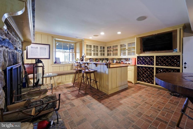 bar with a bar, brick floor, and recessed lighting