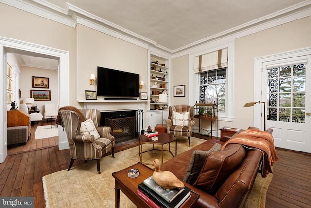 living area with crown molding and hardwood / wood-style floors