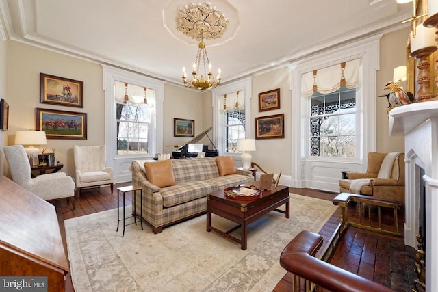 living area featuring a fireplace, a chandelier, crown molding, and hardwood / wood-style flooring