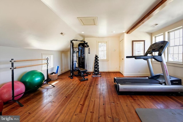workout room featuring baseboards, attic access, visible vents, and hardwood / wood-style flooring