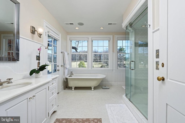 bathroom featuring a freestanding bath, vanity, visible vents, and a stall shower