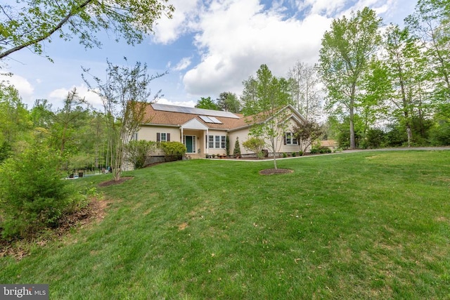 view of front of house with a front yard and solar panels