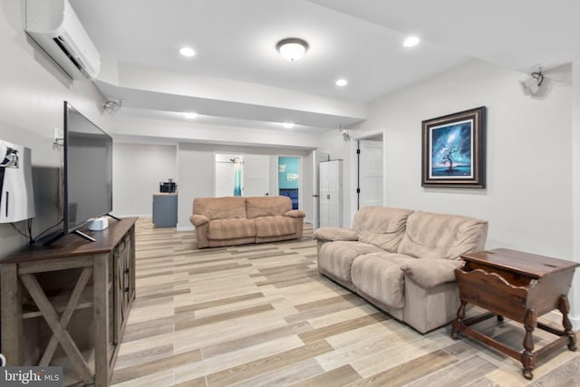 living area with recessed lighting, light wood-style flooring, and a wall unit AC