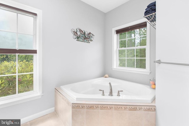 full bathroom featuring baseboards, tile patterned flooring, and a bath