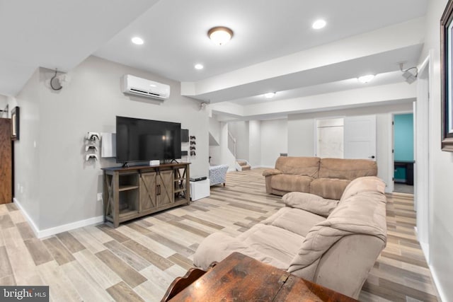 living area featuring baseboards, stairway, a wall mounted air conditioner, and light wood-type flooring