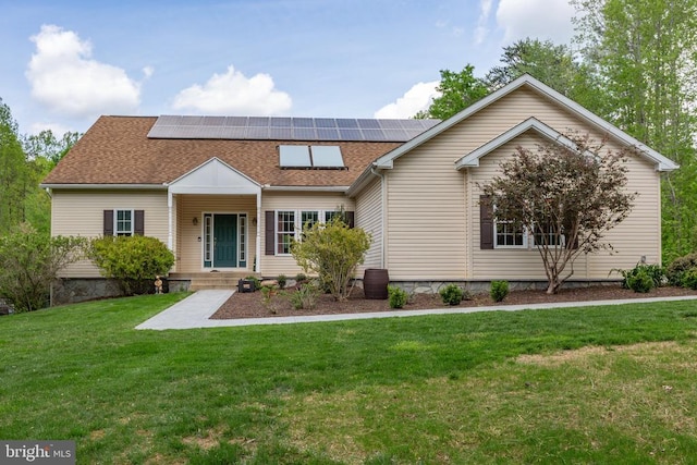 view of front of home featuring a shingled roof, roof mounted solar panels, covered porch, and a front lawn