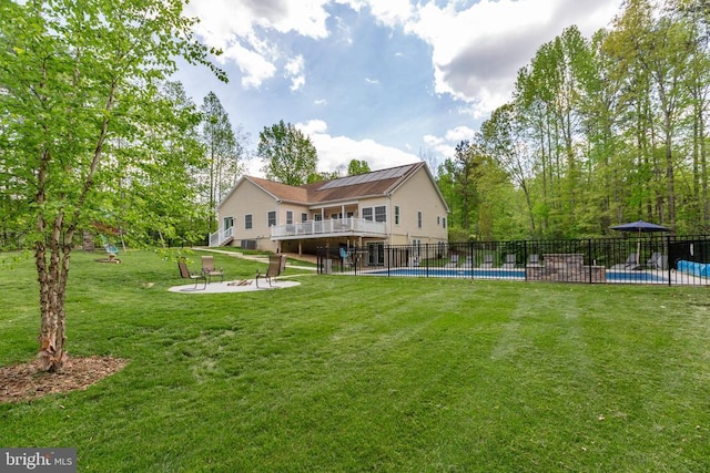 view of yard with a patio, an outdoor fire pit, fence, a wooden deck, and a fenced in pool