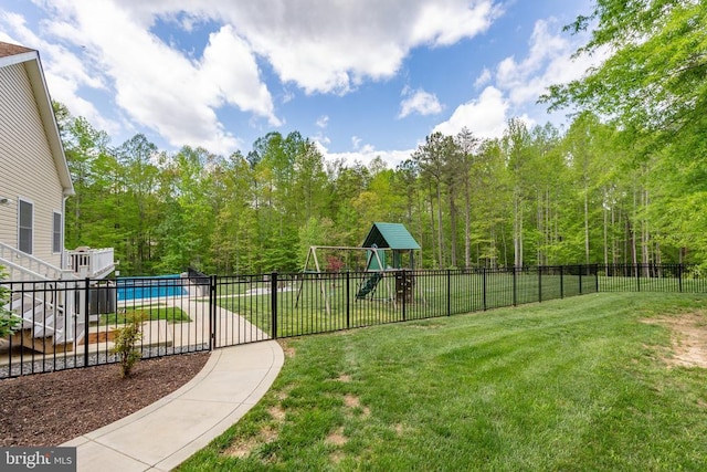 view of yard with playground community, fence, and a fenced in pool