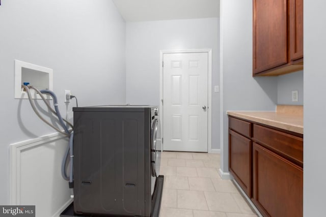 laundry room featuring light tile patterned floors, baseboards, washing machine and clothes dryer, and cabinet space