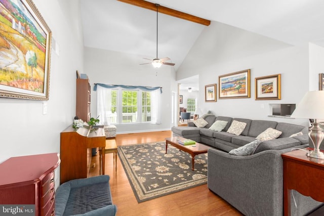 living area featuring a ceiling fan, high vaulted ceiling, beam ceiling, and wood finished floors