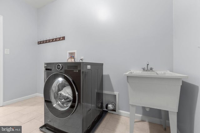laundry area with baseboards, tile patterned floors, washer / clothes dryer, and laundry area