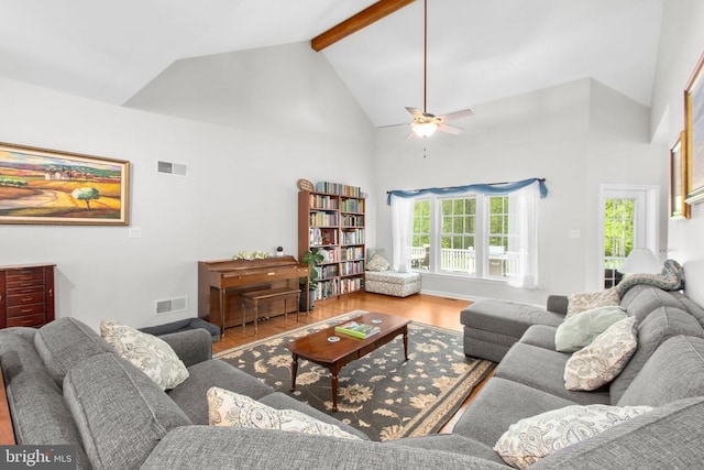 living room featuring visible vents, wood finished floors, a ceiling fan, and high vaulted ceiling