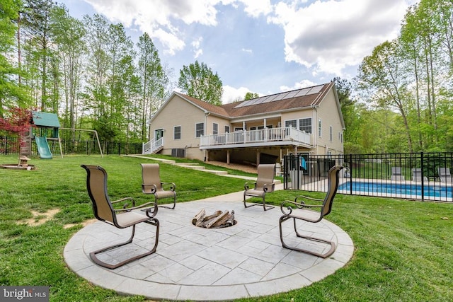 back of property with a fenced in pool, a playground, fence, a yard, and a patio area