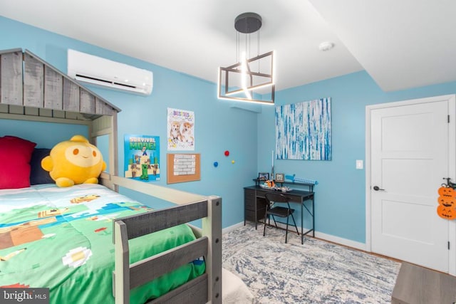 bedroom featuring a chandelier, a wall mounted AC, baseboards, and wood finished floors