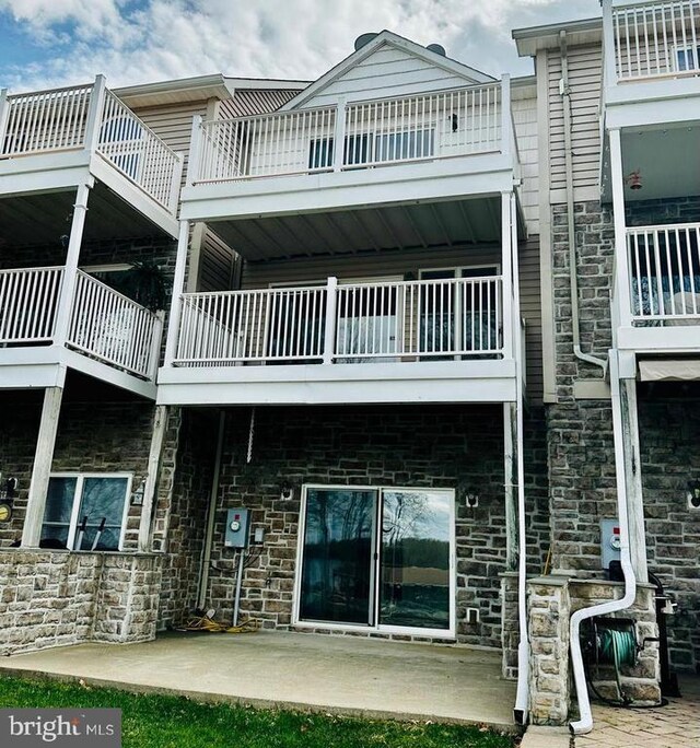 288 Lake Front Dr, Mineral, VA 23117 - back of house featuring a balcony, stone siding, and a patio area