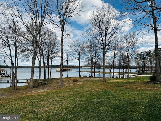 view of green lawn featuring a water view