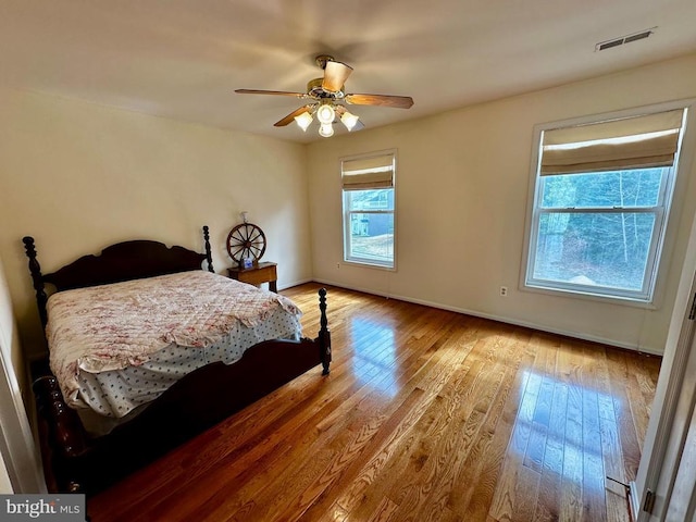 bedroom featuring hardwood / wood-style floors, baseboards, and ceiling fan
