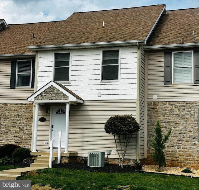 view of front of house with stone siding and central AC