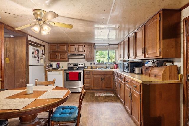 6596 Mayberry Rd, Singers Glen, VA 22850 - kitchen with stainless steel appliances, exhaust hood, brown cabinetry, dark wood-style floors, and light countertops