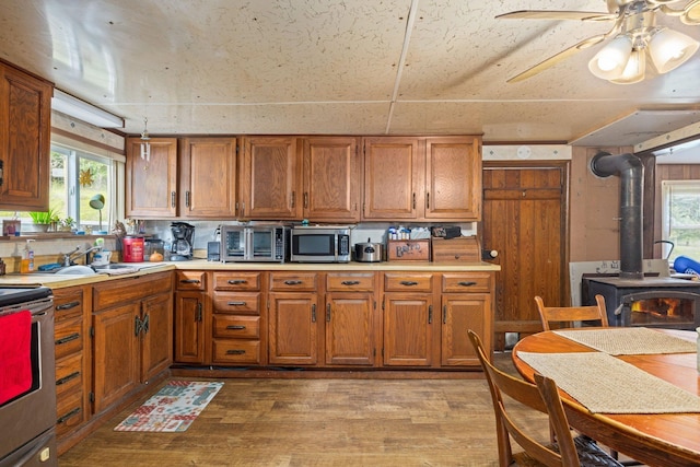 6596 Mayberry Rd, Singers Glen, VA 22850 - kitchen featuring appliances with stainless steel finishes, a wood stove, brown cabinetry, and light countertops