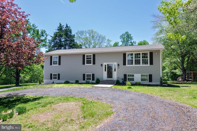 - raised ranch featuring a front yard and curved driveway