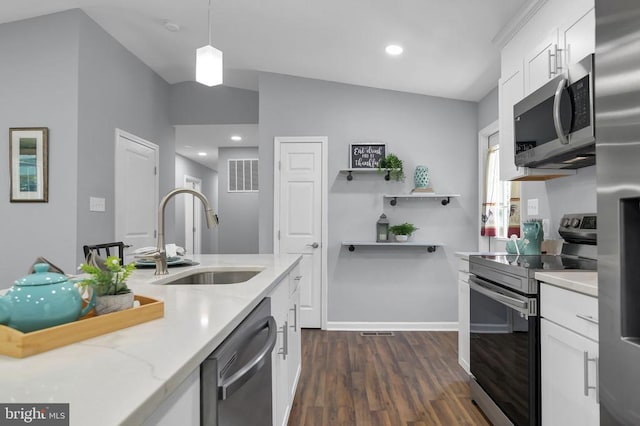  - kitchen featuring appliances with stainless steel finishes, dark wood-style flooring, white cabinetry, light stone countertops, and decorative light fixtures